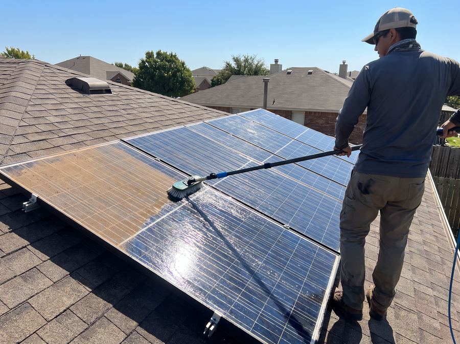 Rooftop solar panels being cleaned, one half dusty and one half gleaming